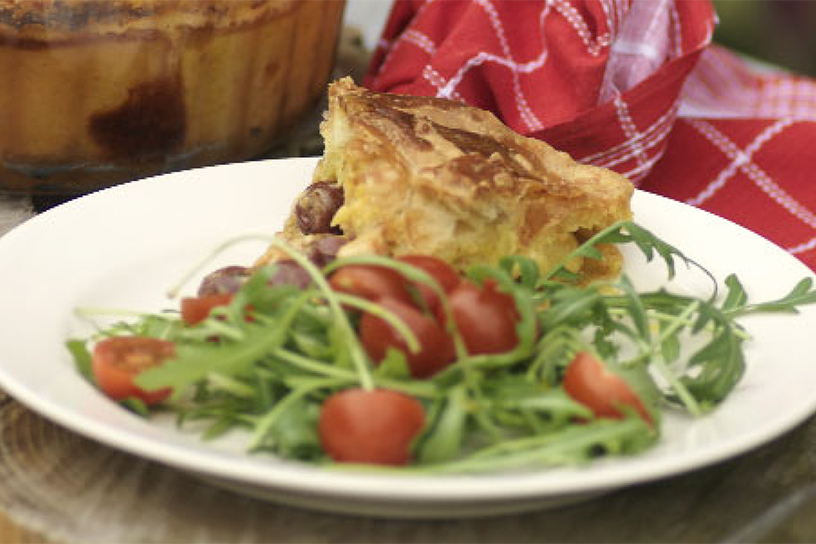 Bord met kipfilet in bladerdeeg en sla van rucola met tomaat